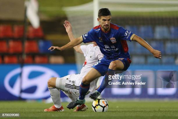 Steven Ugarkovic of the Jets is contested by the Phoenix defence during the round five A-League match between the Newcastle Jets and the Wellington...