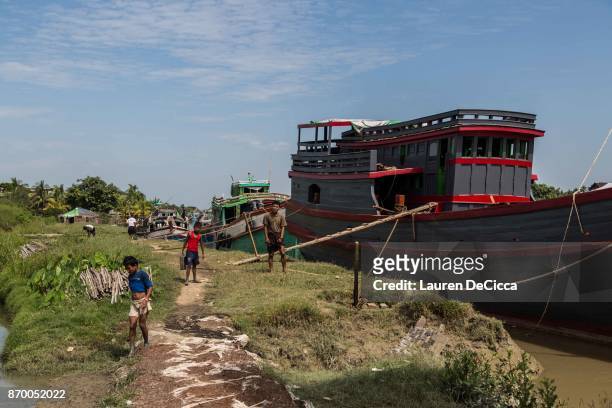 Rakhine Buddhists work on transport ships in the Satroja IDP camp on November 4, 2017 in Sittwe, Myanmar. A segment of the Rakhine Buddhist...