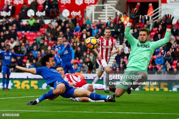 Jack Butland of Stoke City in action with Shinji Okazaki of Leicester City during the Premier League match between Stoke City and Leicester City at...