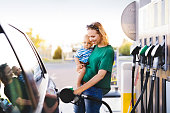 Young mother with baby boy at the petrol station.