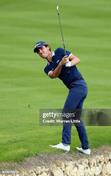 Renato Paratore of Italy plays his second shot into the 18th green from the edge of the pond during the third round of the Turkish Airlines Open at...