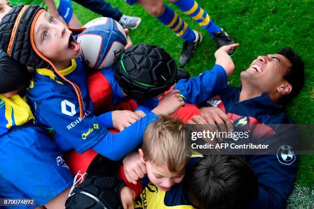 French rugby player Sébastien Vahaamahina plays with children from Pontlieu rugby club, after a training session in Marcoussis near Paris on November...