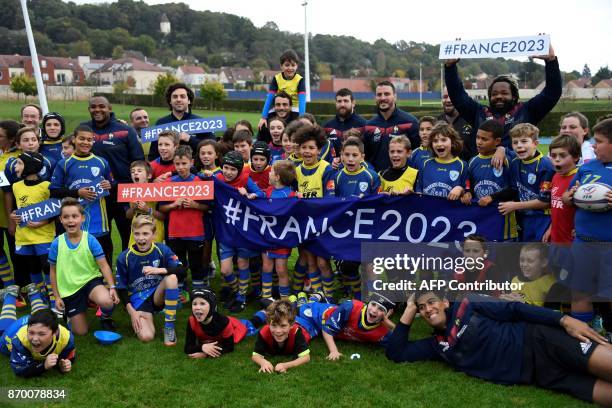 Children from Pontlieu rugby club pose with French rugby players and hold banners and placards refering to France's bid to host the 2023 Rugby World...