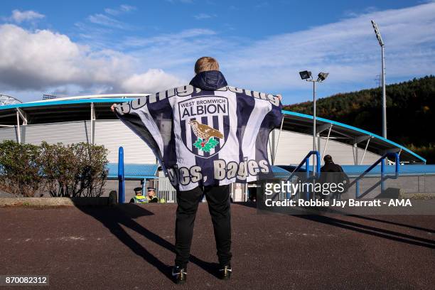 Fan of West Bromwich Albion holds up a flag outside The John Smiths Stadium, home stadium of Huddersfield Town prior to the Premier League match...