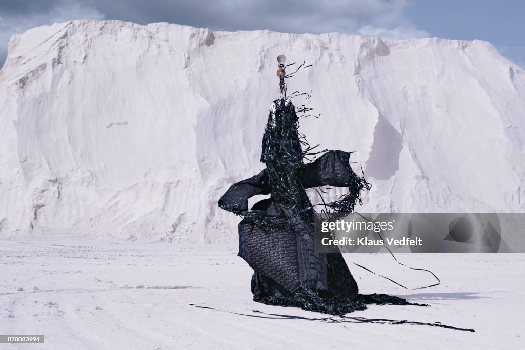 Man wearing amazing costume, made out of old CD's and videotapes - in limestone landscape