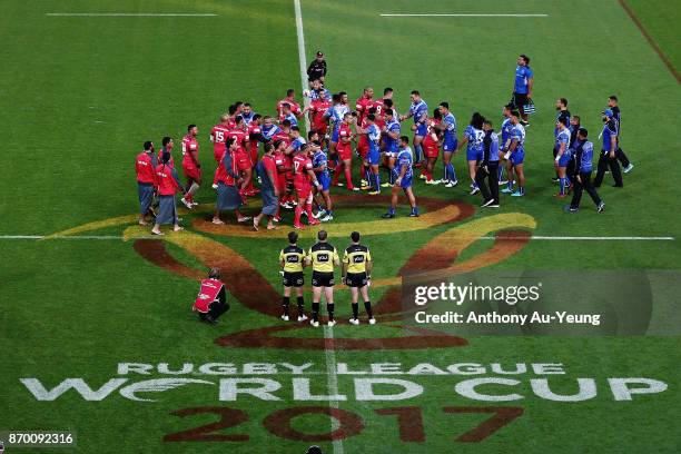 Players from both teams acknowledge each other with hugs prior to the 2017 Rugby League World Cup match between Samoa and Tonga at Waikato Stadium on...