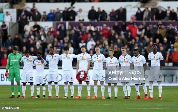 Players line up for a minute's silence ahead of Remembrance Sunday prior to the Premier League match between Swansea City and Brighton and Hove...