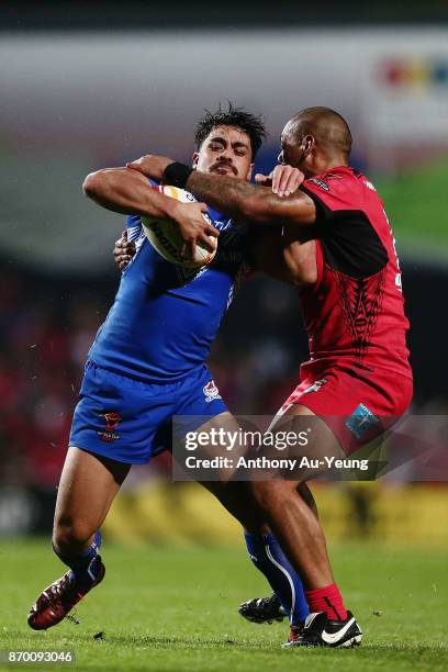 Young Tonumaipea of Samoa is tackled by Sika Manu of Tonga during the 2017 Rugby League World Cup match between Samoa and Tonga at Waikato Stadium on...