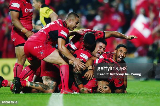 Manu Ma'u of Tonga is mobbed by teammates after scoring a try during the 2017 Rugby League World Cup match between Samoa and Tonga at Waikato Stadium...