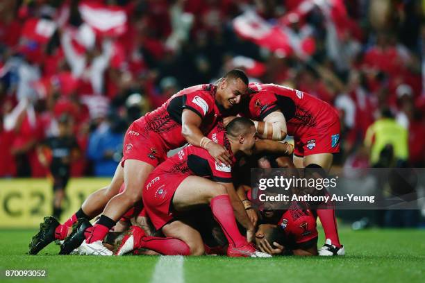 Manu Ma'u of Tonga is mobbed by teammates after scoring a try during the 2017 Rugby League World Cup match between Samoa and Tonga at Waikato Stadium...