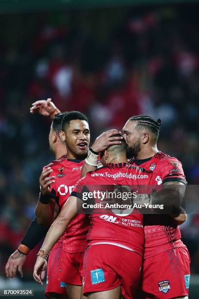 Ben Murdoch-Masila of Tonga celebrates with teammates Tuimoala Lolohea and David Fusitu'a after scoring a try during the 2017 Rugby League World Cup...