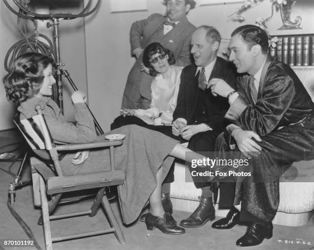 American actress Katharine Hepburn on the set of the film 'Break of Hearts' with co-star Charles Boyer and director Philip Moeller , 1935.