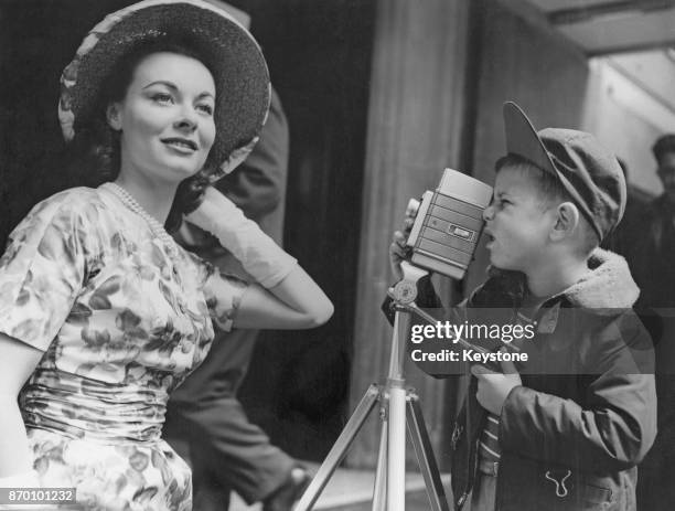 British actress Anne Heywood poses for six-year-old Robert Rodgers of Ealing, who is using a 'magic eye' movie camera on a miniature tripod, at the...