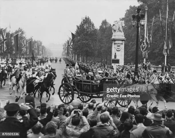 West German President Theodor Heuss travels by landau from Victoria Station in London to Buckingham Palace, accompanied by Queen Elizabeth II and the...
