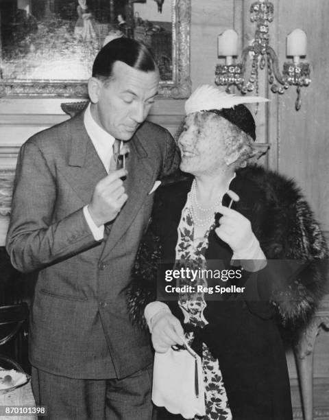English actress and singer Ellaline Terriss , the wife of actor Sir Seymour Hicks, with Noel Coward at a cocktail party held by Lord and Lady Selsdon...