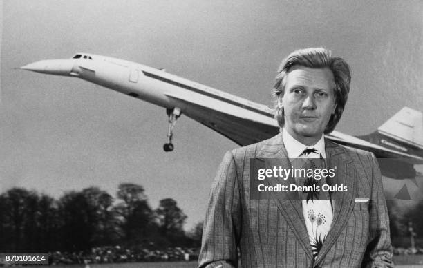 Michael Heseltine, the Minister of State for Aerospace and Shipping, in front of a photograph of the supersonic airliner Concorde, 5th July 1972.