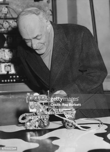 English physical chemist and Nobel laureate Cyril Norman Hinshelwood , President of the Royal Society, examines a 'Learning Machine' at the Physical...