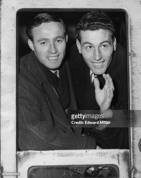 Arsenal players Jimmy Bloomfield and captain Cliff Holton leave Euston Station in London for their cup-tie match with Preston North End, 15th...