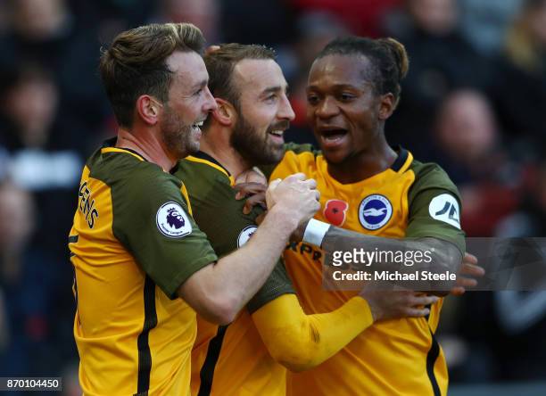 Glenn Murray celebrates scoring his side's first goal with Dale Stephens and Gaetan Bong of Brighton and Hove Albion during the Premier League match...