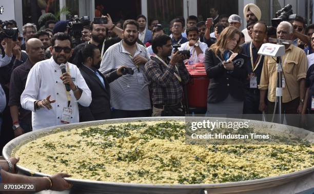 Indian chef Sanjeev Kapoor along with other wait for the khichdi at World Food Festival at India Gate, on November 4, 2017 in New Delhi, India. A...