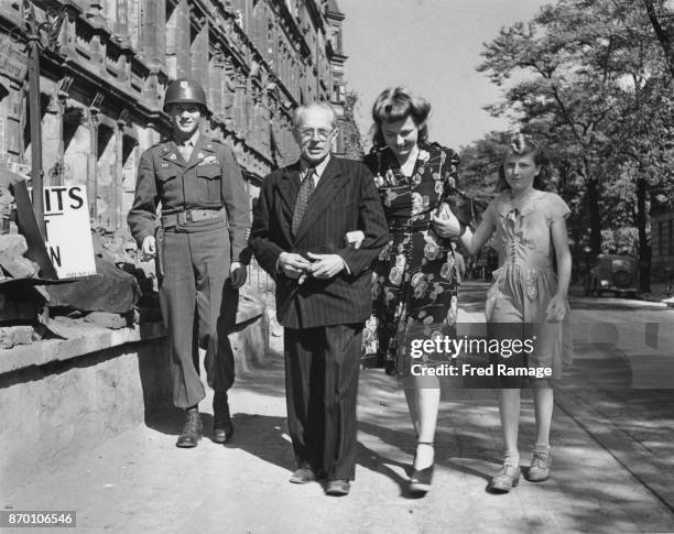 Heinrich Hoffmann , official photographer to Adolf Hitler, out walking in Nuremberg with his wife and step-daughter, and an armed guard, 28th...