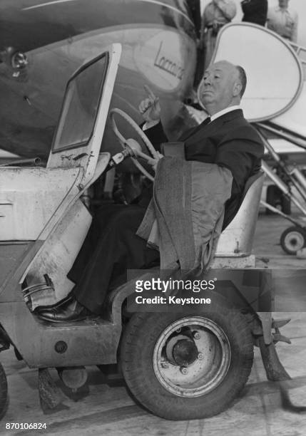 English film director Alfred Hitchcock rides a baggage trolley upon his arrival at Paris airport, France, 1st October 1960.