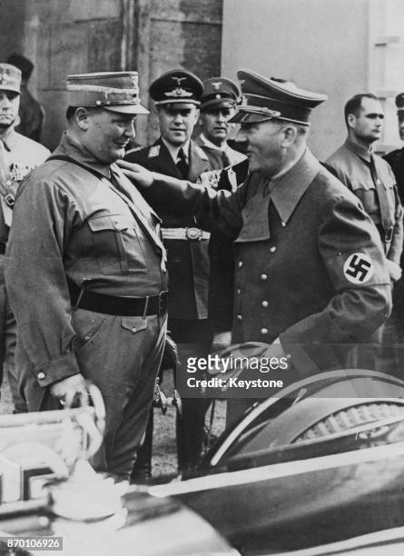German Chancellor Adolf Hitler gives Hermann Goering , President of the Reichstag, a friendly pat on the shoulder during a view of troops at Luitpold...