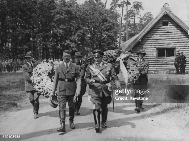 German Chancellor Adolf Hitler with Hermann Goering , and a procession of men carrying wreaths, 1934.