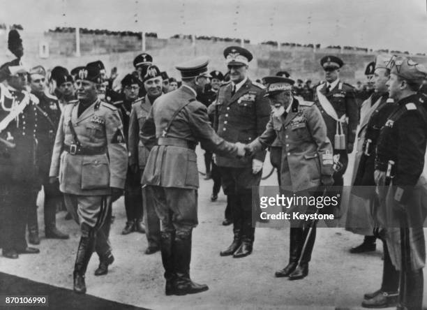 German Chancellor Adolf Hitler is greeted by Italian Marshal Emilio De Bono upon his arrival at the Francesco Baracca Aerodrome in Rome, Italy, to...