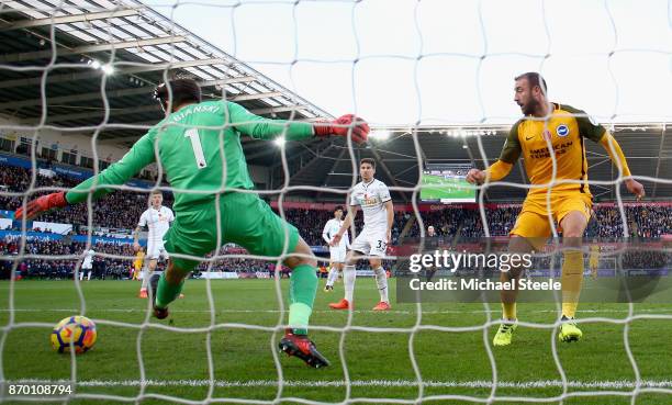 Glenn Murray of Brighton and Hove Albion beats Lukasz Fabianski of Swansea City as he scores his side's first goal during the Premier League match...