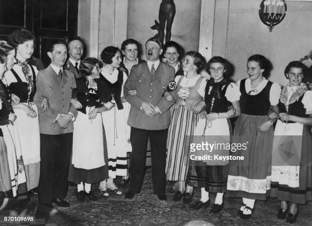 German Chancellor Adolf Hitler and a group of young women from the Rhineland in national costumes visit Propaganda Minister Joseph Goebbels at the...