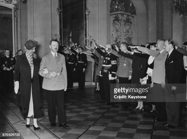 German Chancellor Adolf Hitler escorts Madame Horthy, the wife of Hungarian Admiral and Regent Miklos Horthy, to breakfast at the Charlottenburg...