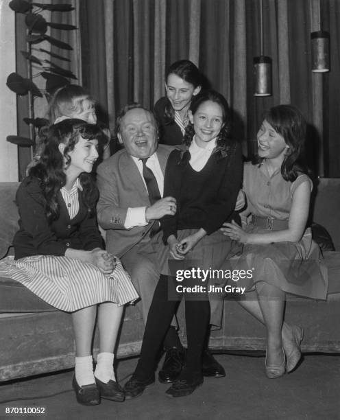 Aspiring actress Olivia Hussey sits on the knee of English actor and comedian Charlie Drake during an audition, June 1963. She recited the poem 'The...