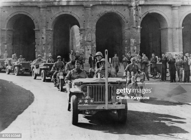 Lieutenant General Mark W. Clark , commander of the United States Fifth Army, passes the ancient Coliseum in Rome, Italy, after capturing the city...