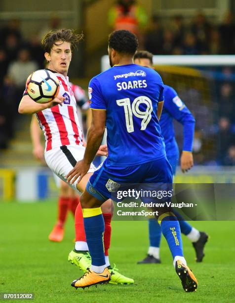 Lincoln City's Alex Woodyard vies for possession with AFC Wimbledon's Tom Soares during the Sky Bet League One match between A.F.C. Wimbledon and...