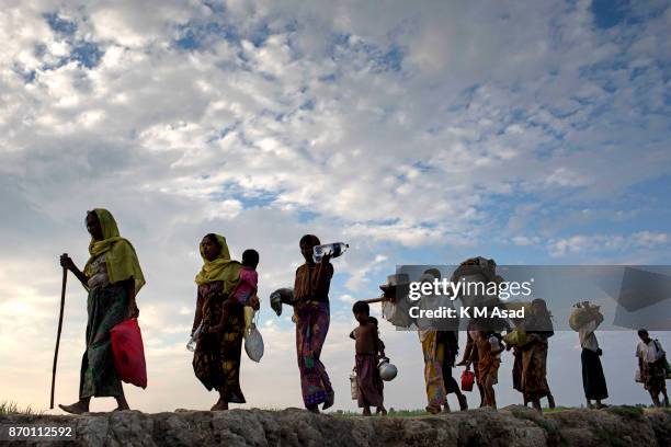 Rohingya refugee people walk through paddy field entered Bangladesh from Myanmar Rakhine state at Anjumanpara in Coxsbazar, Bangladesh. According to...