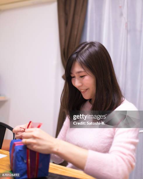 happy yong woman wrapping present in home - i love my wife stock pictures, royalty-free photos & images