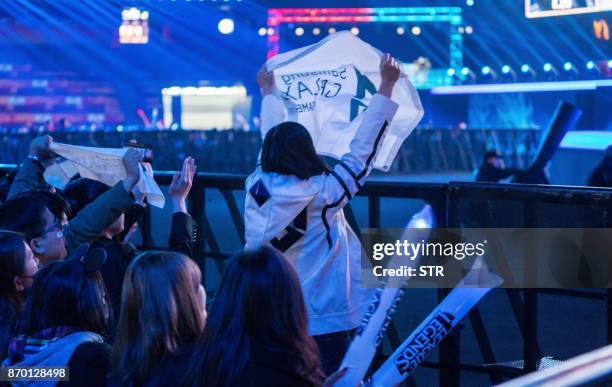 Fan of the team Samsung Galaxy waves the flag of the team during the World Championships Final of League of Legends at the National Stadium 'Bird's...