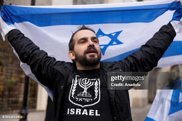 Man holds up Israeli flag as pro-Palestinian supporters hold a national march through central London, England, on November 4 demanding justice and...