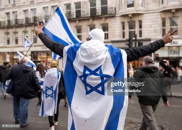 Pro-Israel group hold Israeli flags as pro-Palestinian supporters hold a national march through central London, England, on November 4 demanding...