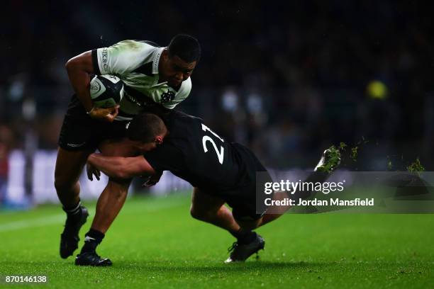 Julian Savea of the Barbarians is tackled by Tawera Kerr-Barlow of New Zealand during the Killik Cup match between Barbarians and New Zealand at...