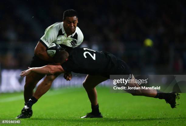 Julian Savea of the Barbarians is tackled by Tawera Kerr-Barlow of New Zealand during the Killik Cup match between Barbarians and New Zealand at...