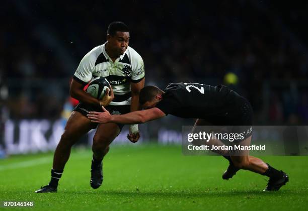 Julian Savea of the Barbarians is tackled by Tawera Kerr-Barlow of New Zealand during the Killik Cup match between Barbarians and New Zealand at...