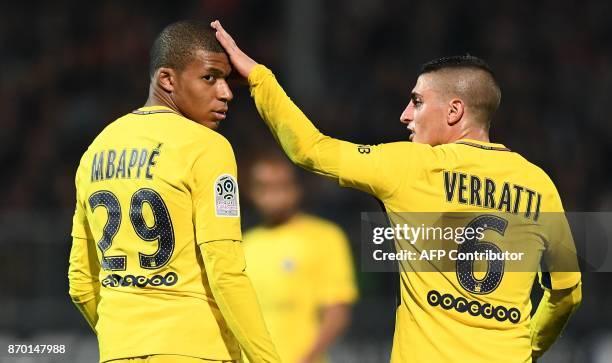 Paris Saint-Germain's Italian midfielder Marco Verratti touches the head of Paris Saint-Germain's French forward Kylian MBappe during the French L1...