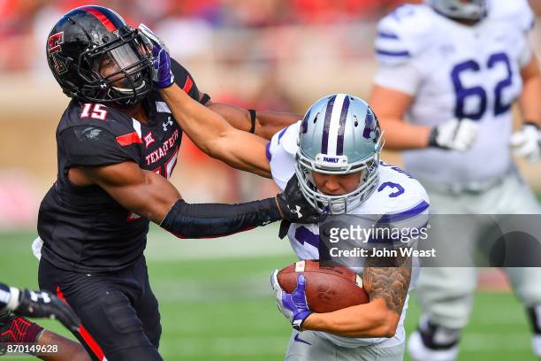 Dalvin Warmack of the Kansas State Wildcats tries to break away from Vaughnte Dorsey of the Texas Tech Red Raiders during the first half of the game...