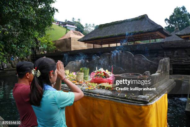 locals praying at pura tirta empul, bali - tirta empul temple stock pictures, royalty-free photos & images