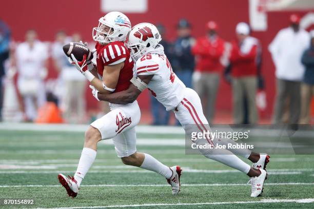 Luke Timian of the Indiana Hoosiers gets hit after a catch against Derrick Tindal of the Wisconsin Badgers in the first quarter of a game at Memorial...