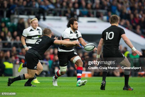 Steven Luatua of the Barbarians offloads under pressure from New Zealands Nathan Harris during the Killik Cup match between Barbarians and New...