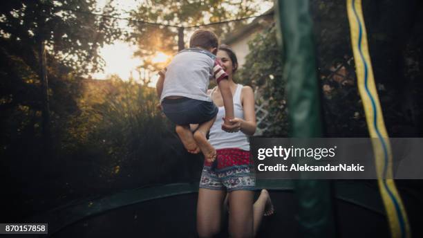 pojken och hans mamma på en studsmatta - trampolin bildbanksfoton och bilder