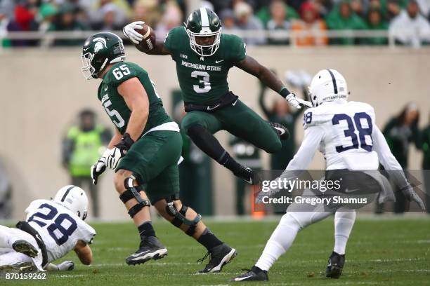 Scott of the Michigan State Spartans jumps past the tackle of Troy Apke of the Penn State Nittany Lions during the first half at Spartan Stadium on...